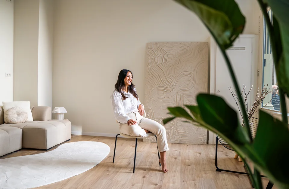 Ondernemer in witte outfit op een bank in een daglichtstudio