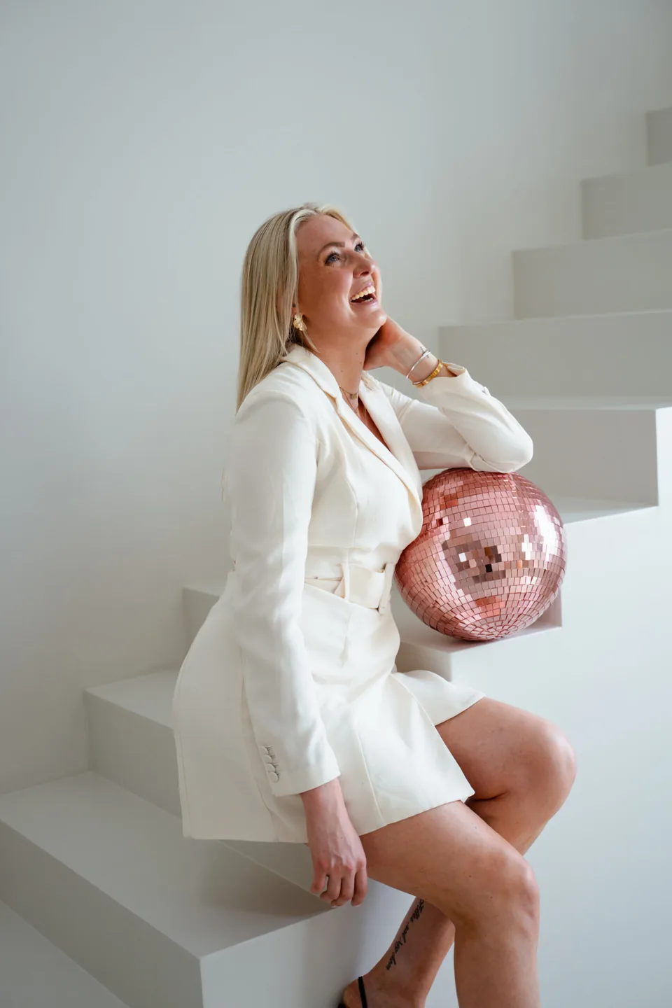 Ondernemer met een discobal op een witte trap