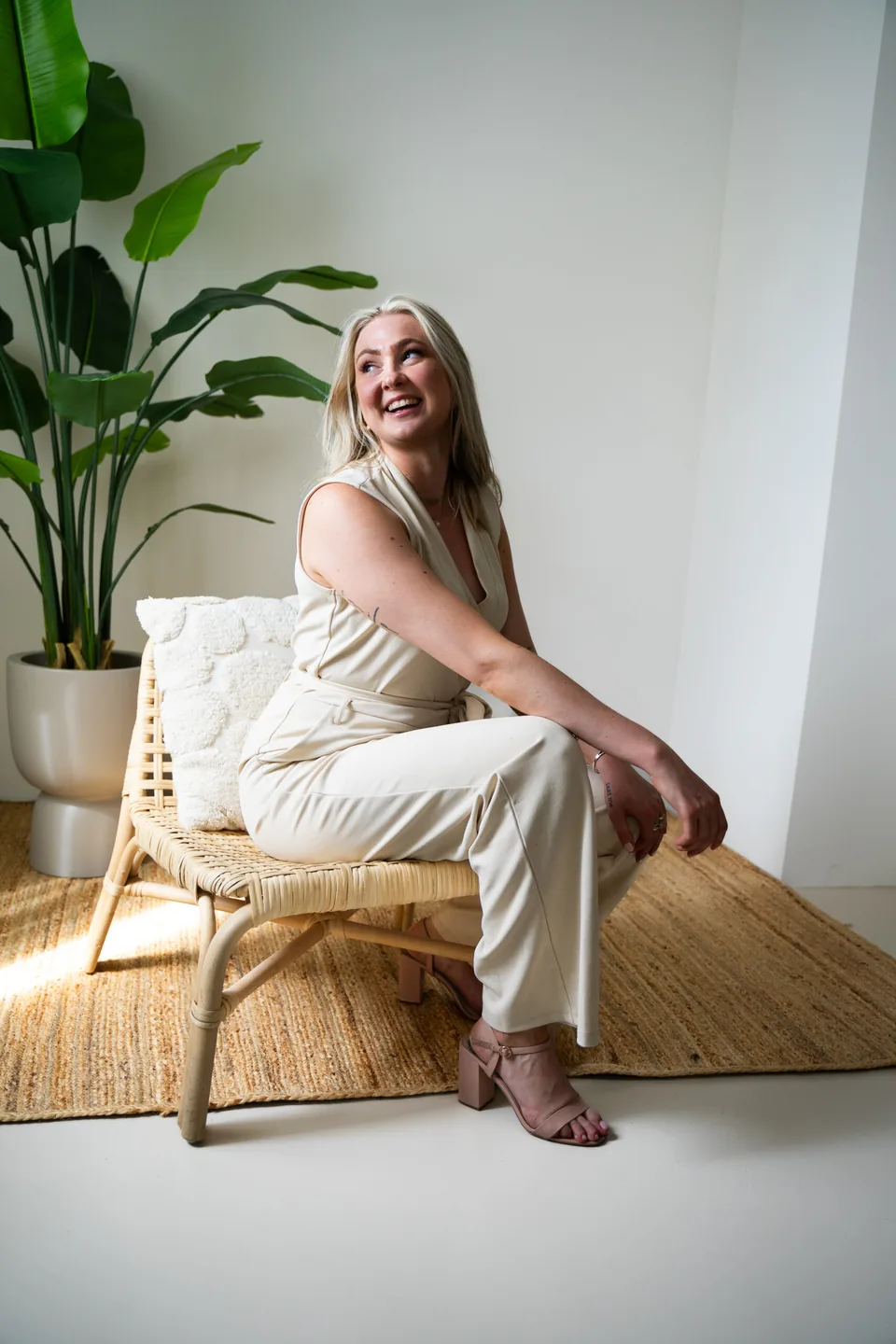 Ondernemer lacht op een houten stoel bij een plant