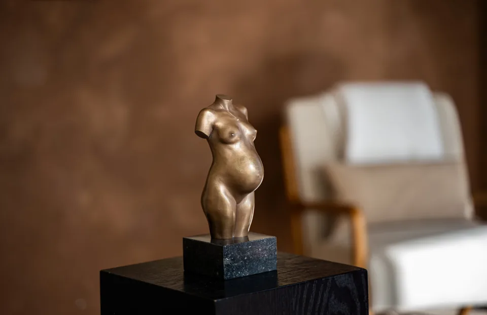 Bronzen beeldje van een vrouwenfiguur op een boek