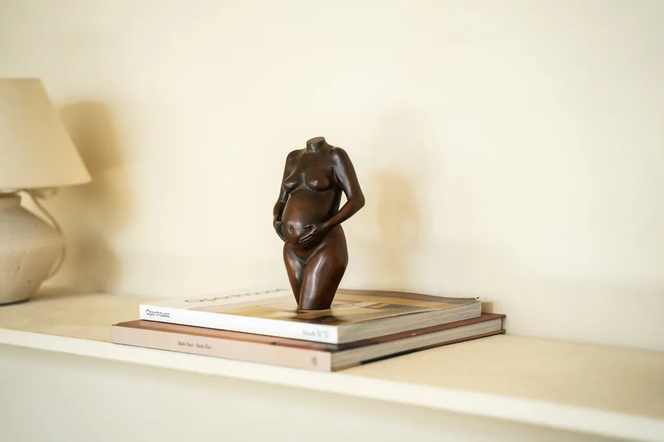 Bronzen beeldje van MOA op een stapel boeken