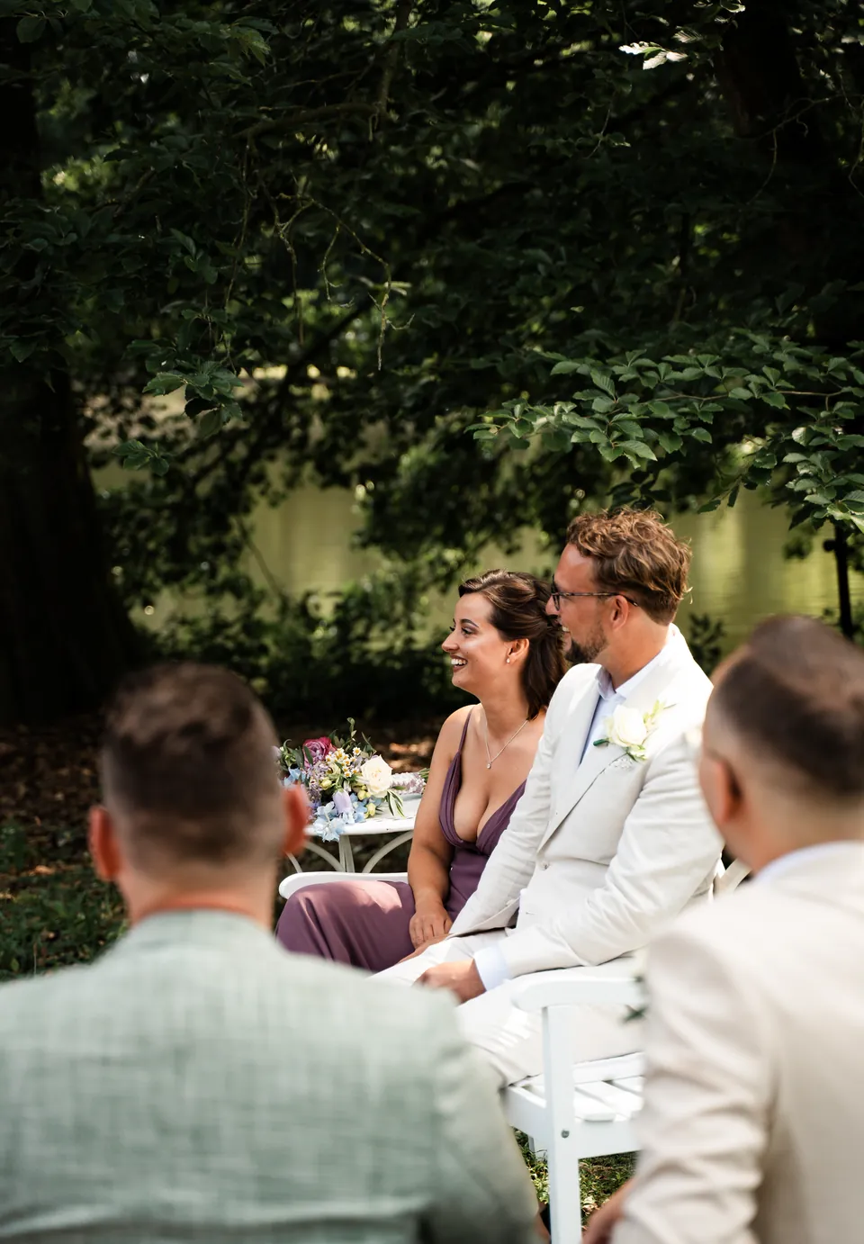 Bruidspaar lacht tijdens de ceremonie in de buitenlucht