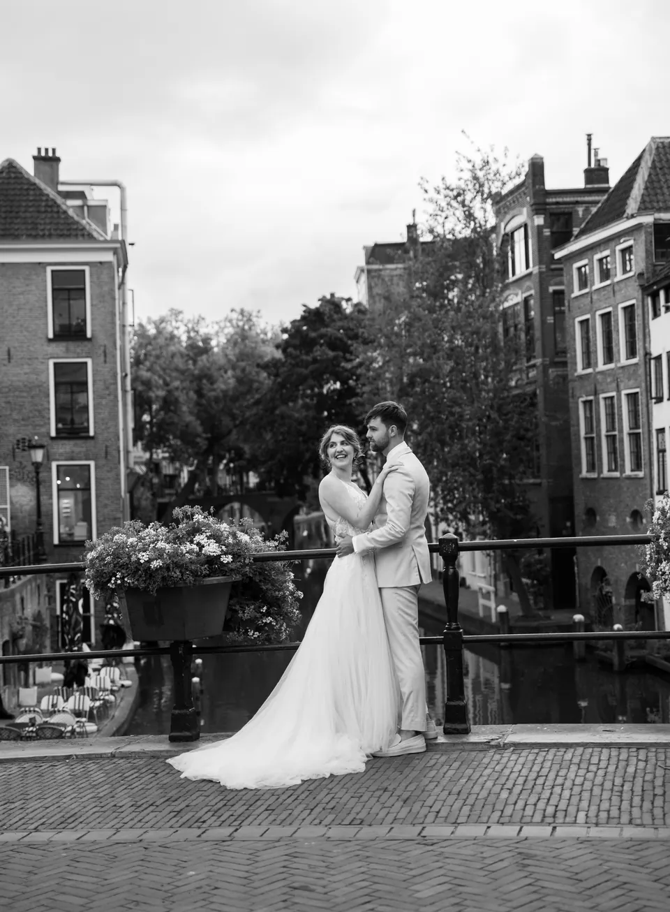 Zwart-witfoto van het bruidspaar op een grachtenbrug