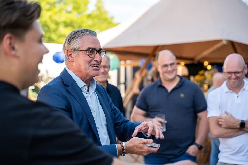 Gasten in gesprek tijdens een bedrijfsevent bij een tent