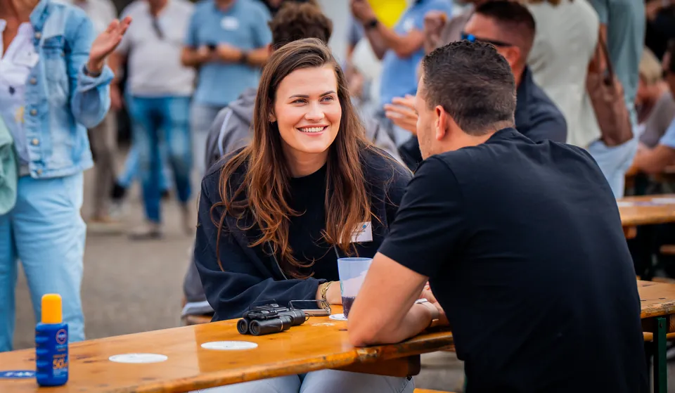 Gasten praten aan een picknicktafel tijdens een bedrijfsevent