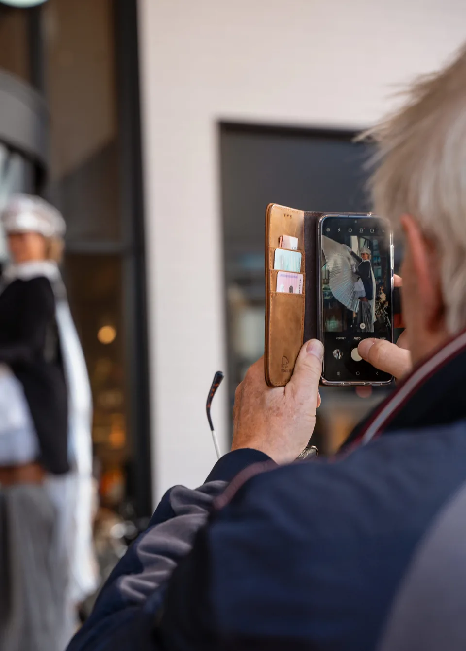 Bezoeker fotografeert een artiest met zijn telefoon