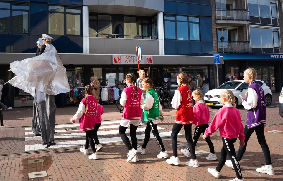 Dansgroep in roze steekt de straat over