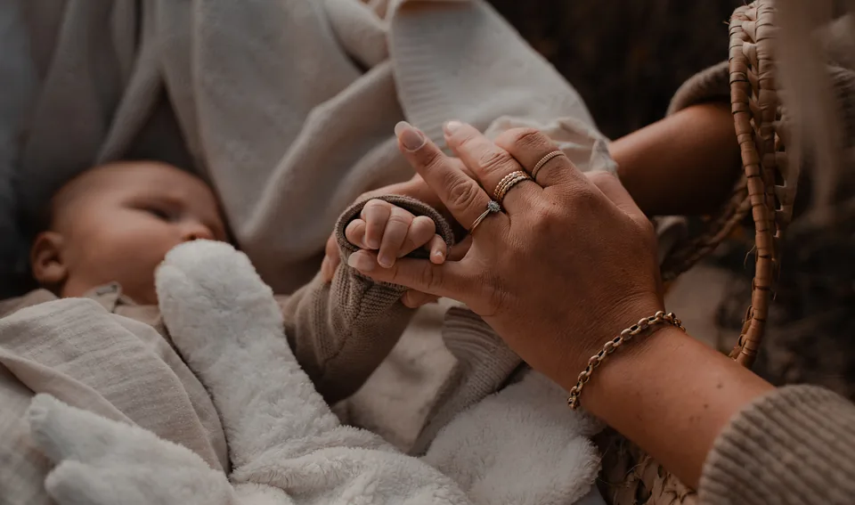 Babyhandjes in de handen van moeder