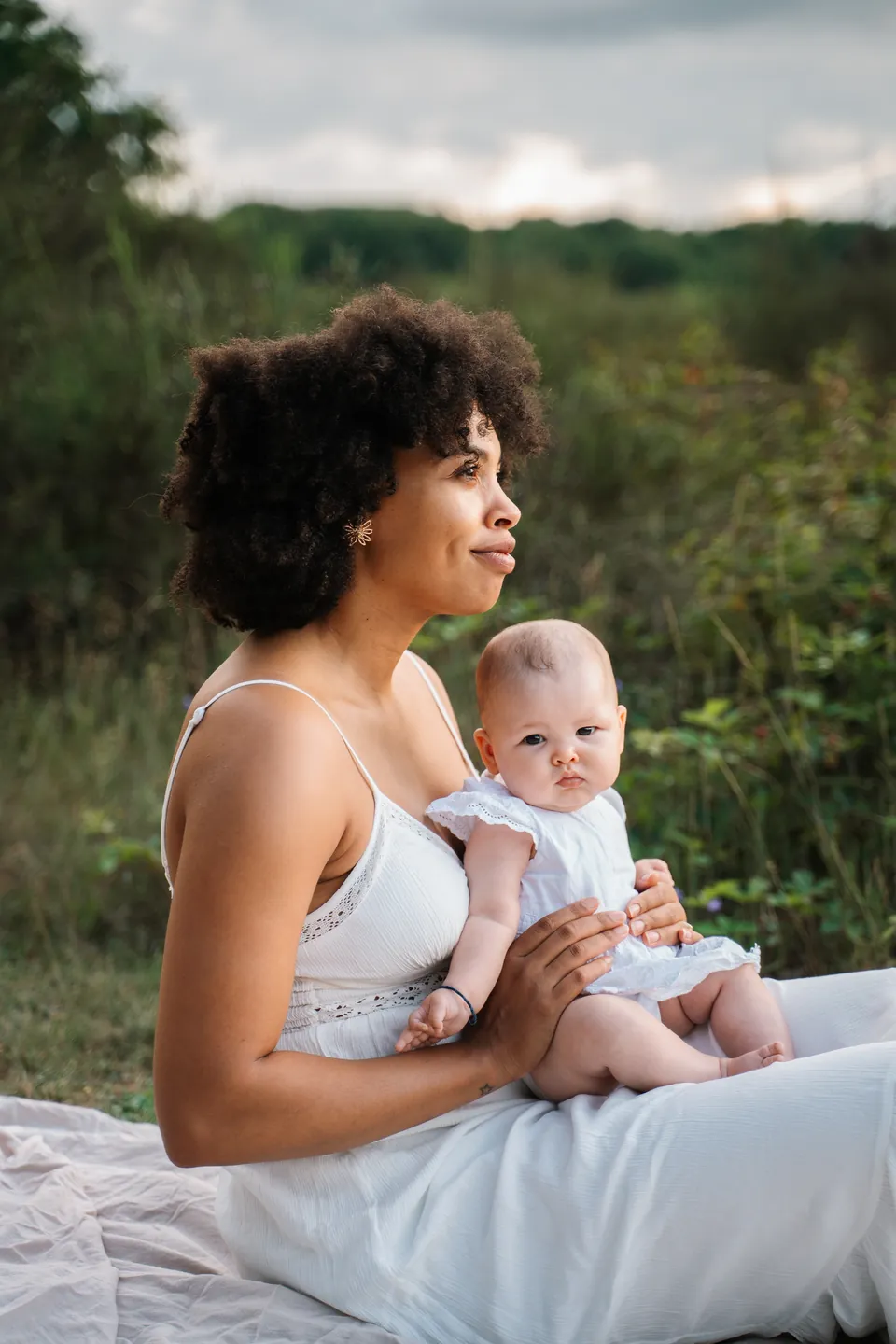 Moeder met haar baby op schoot in de natuur