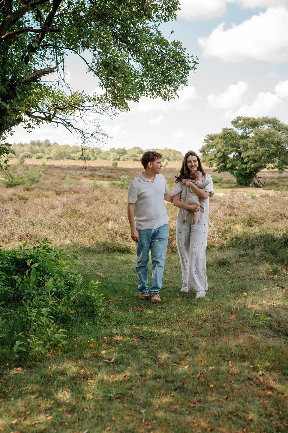 Ouders met hun baby onder een boom op de heide