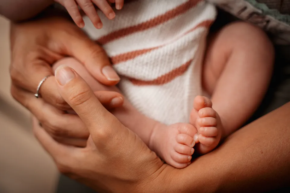 Babyvoetjes in de handen van moeder